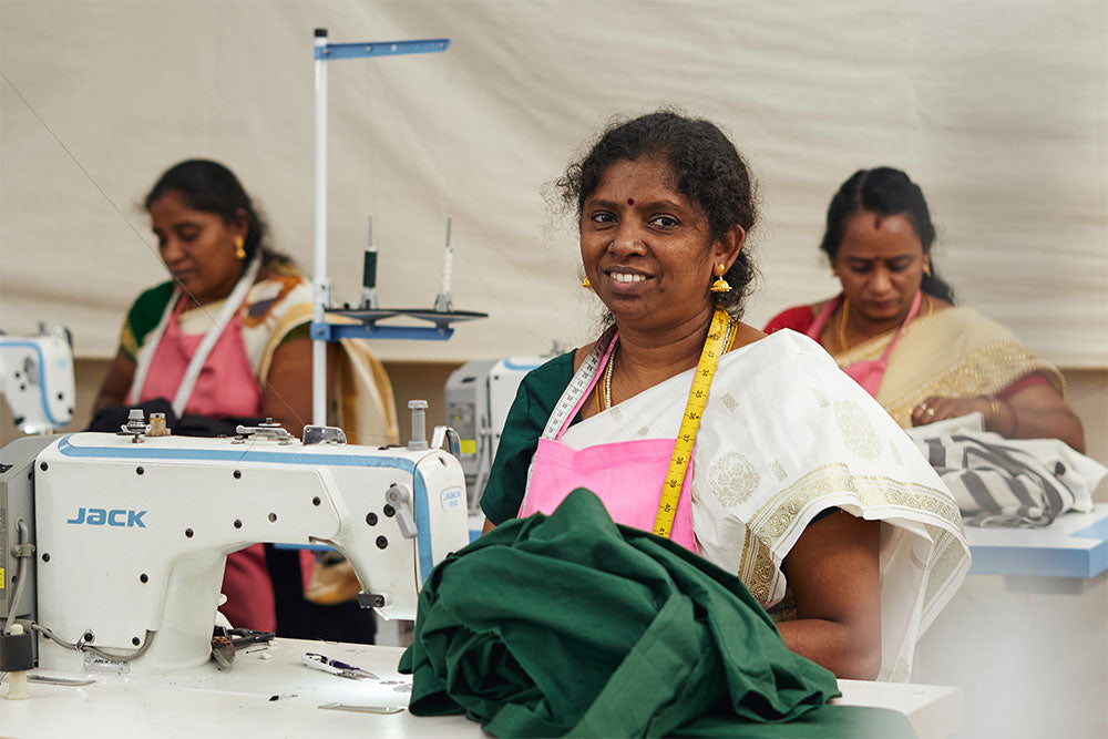 Indian woman at studio blank smiling and holding fabric in the sewing factory 