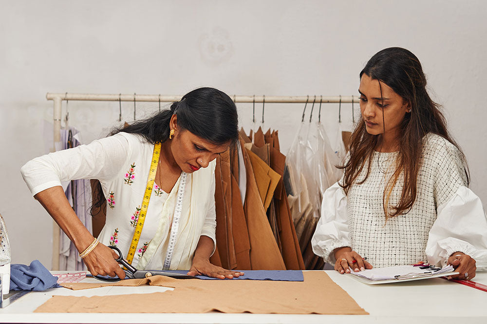 Two Indian women at Blank Studio cutting fabrics in factory 