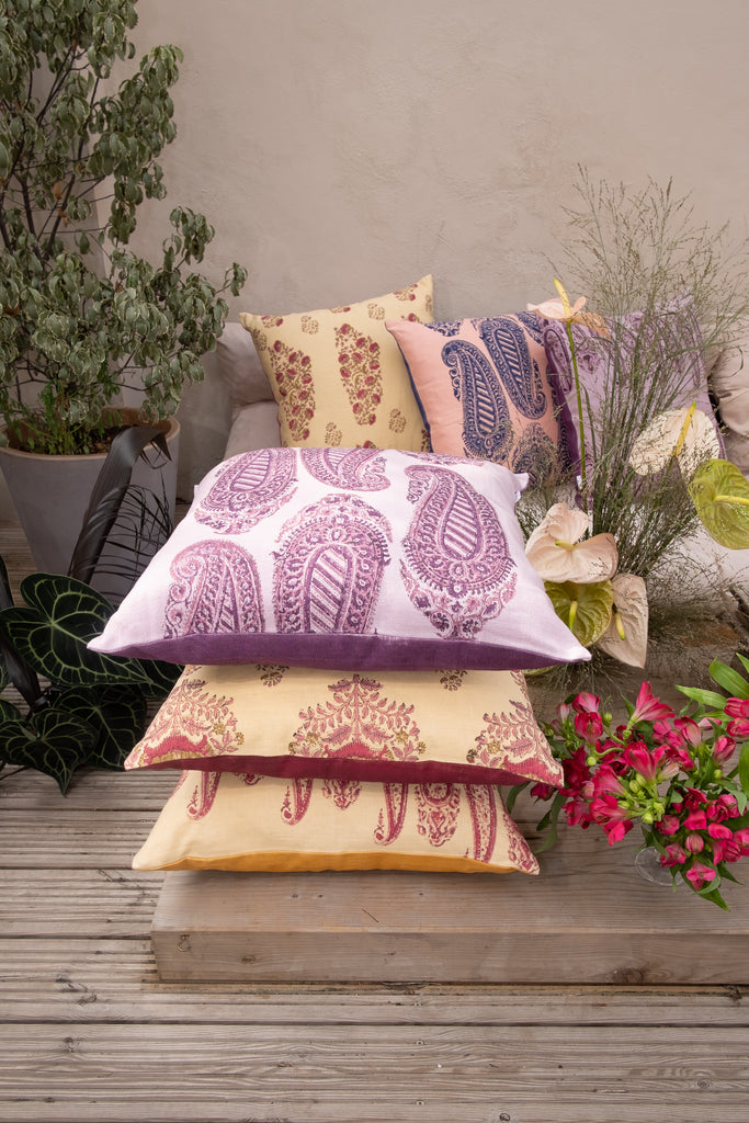 Garden with outside seating with colourful block printed linen cushions yellow pink purple red and flowers and trees.
