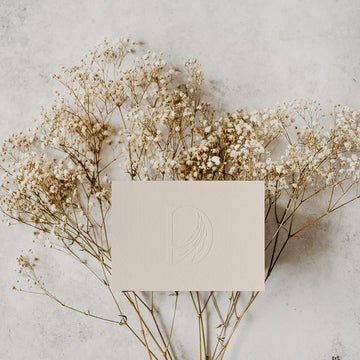 gift card image of embossed daughters of gaea logo lying over dried flowers